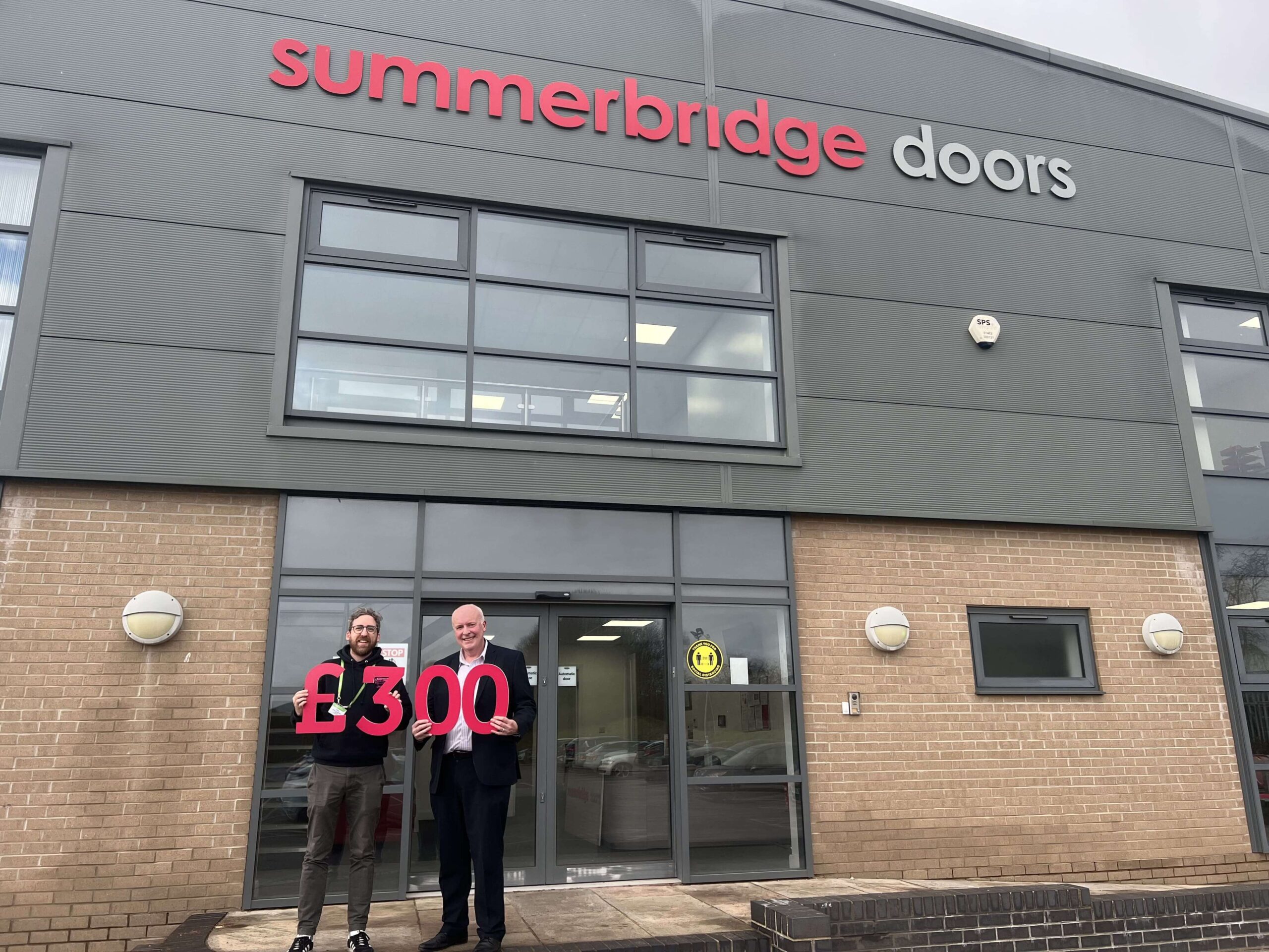 Jethro Shearring (left), Senior Fundraiser (Trusts) at Dove House, is pictured with Mark Newton (right), Sales Director at Summerbridge, outside Summerbridge’s office in Anlaby, Hull