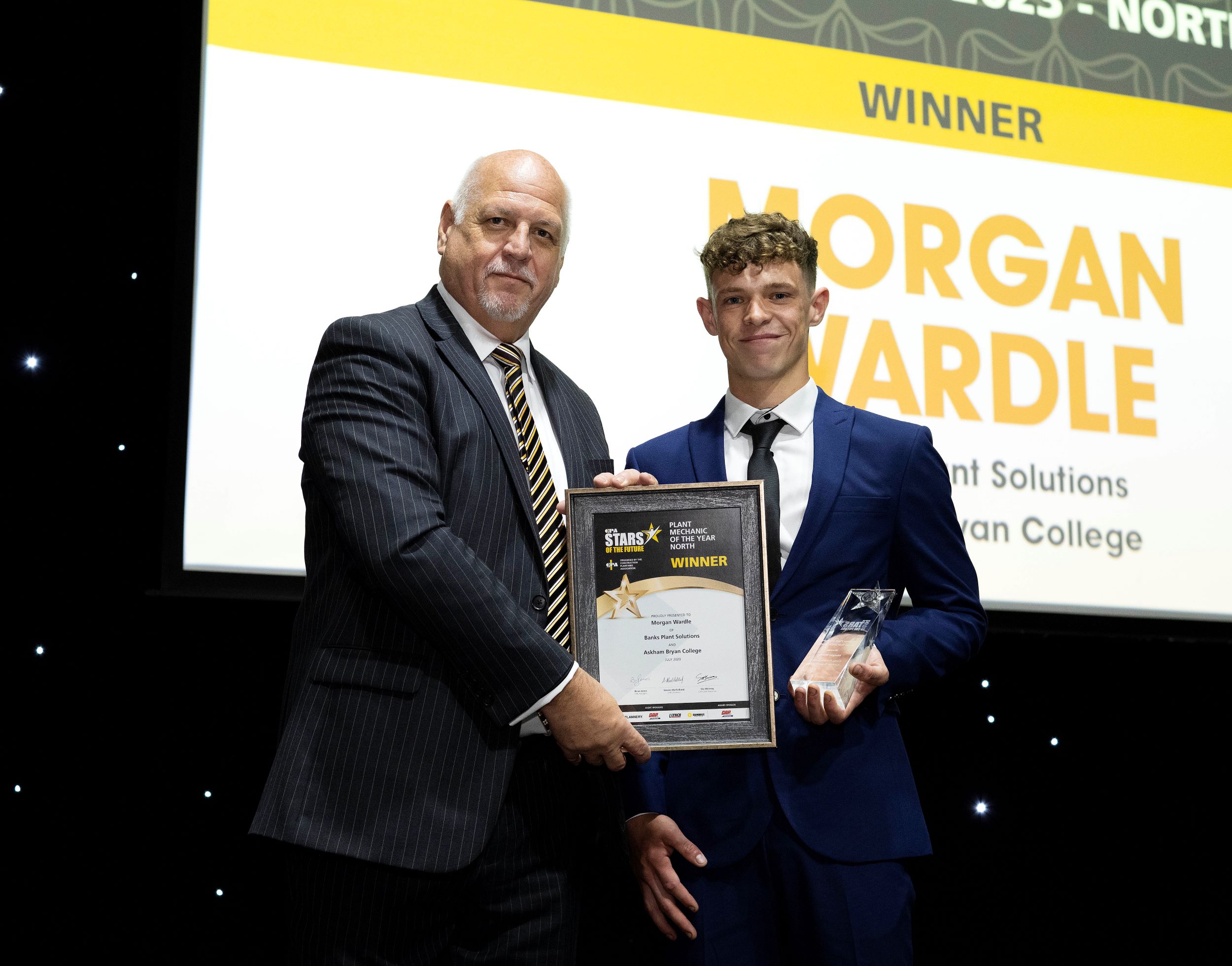 Stu McInroy, chief executive of the Construction Plant-hire Association, presenting Morgan Wardle with his award