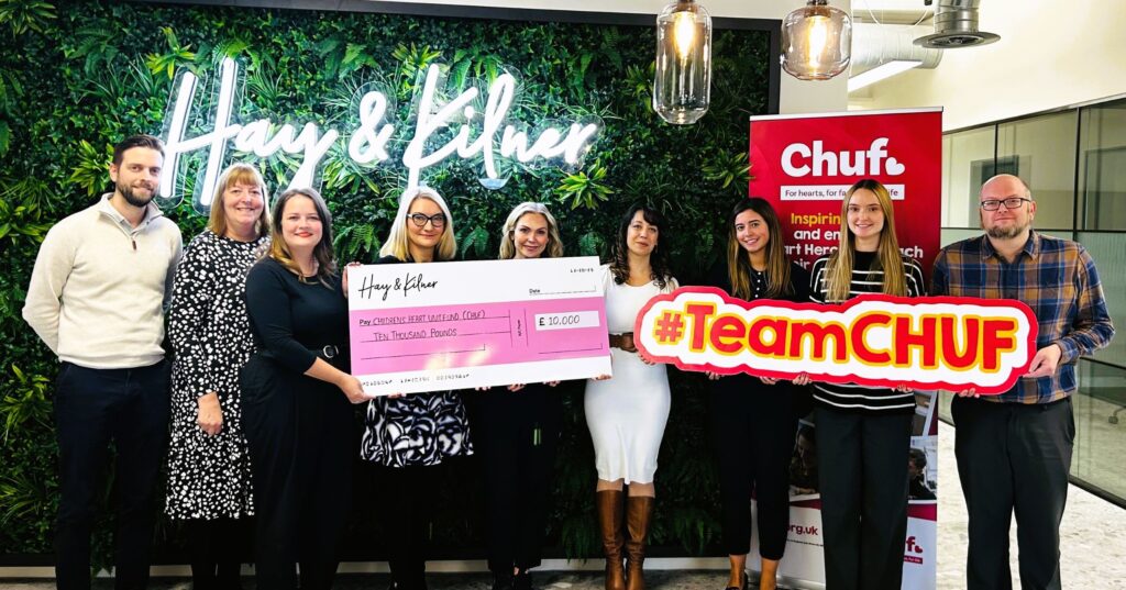members of the Hay & Kilner team presenting a cheque for £10,000 to Alicia Clovis-Mothalib, corporate & trusts fundraising manager at Chuf