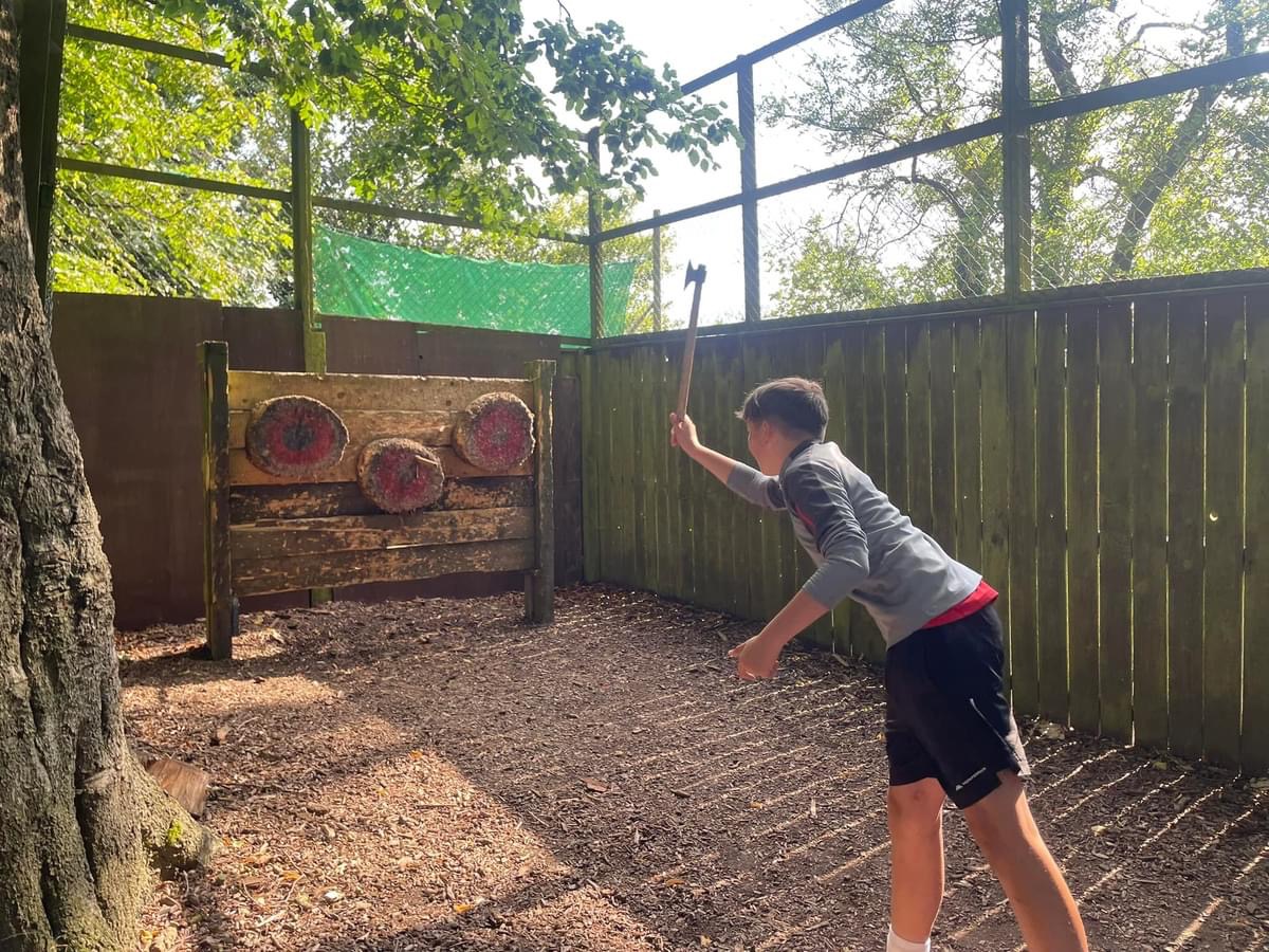 A young person tries out axe throwing at one of Durham Area Youth's summer activity sessions